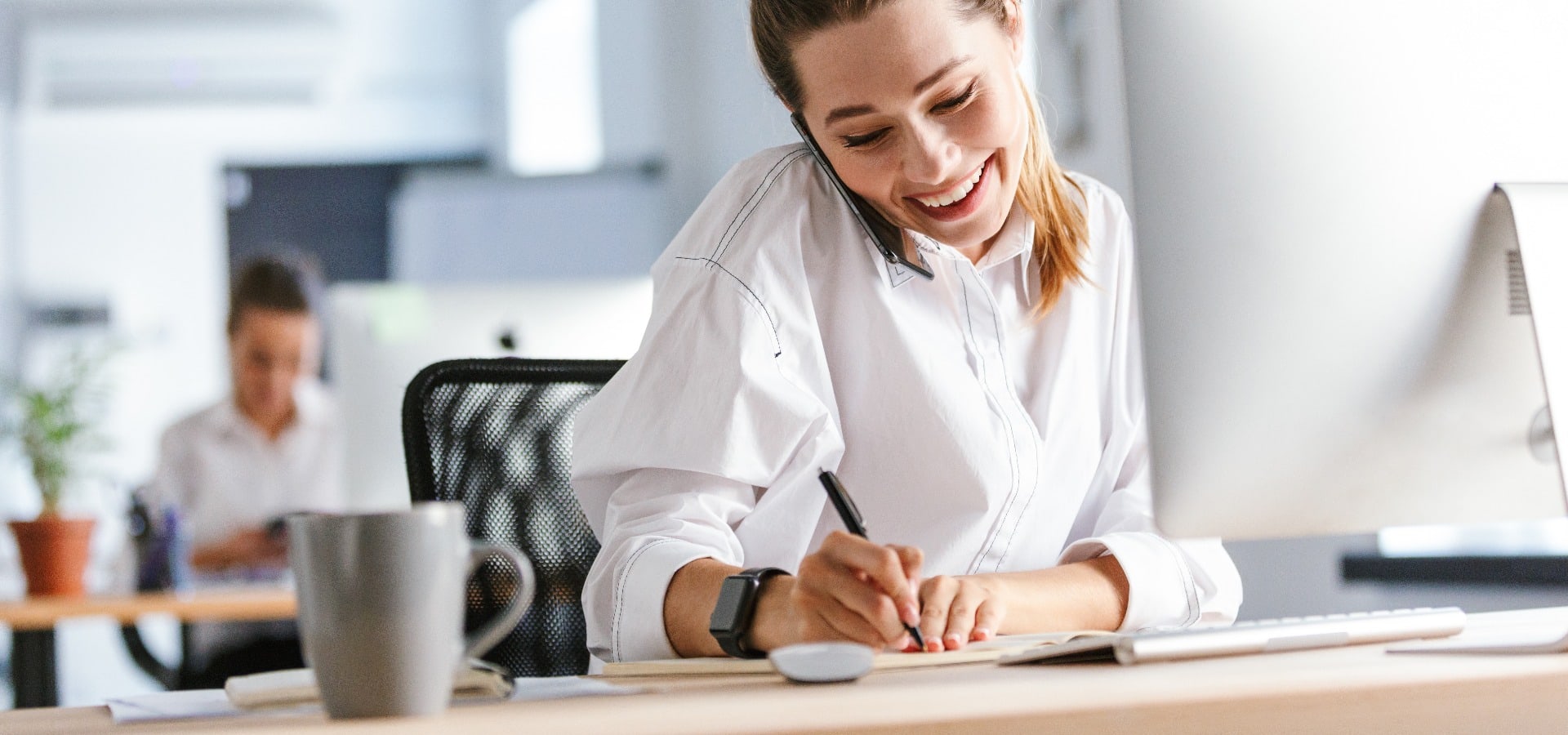 Cheerful young businesswoman sitting at her workplace